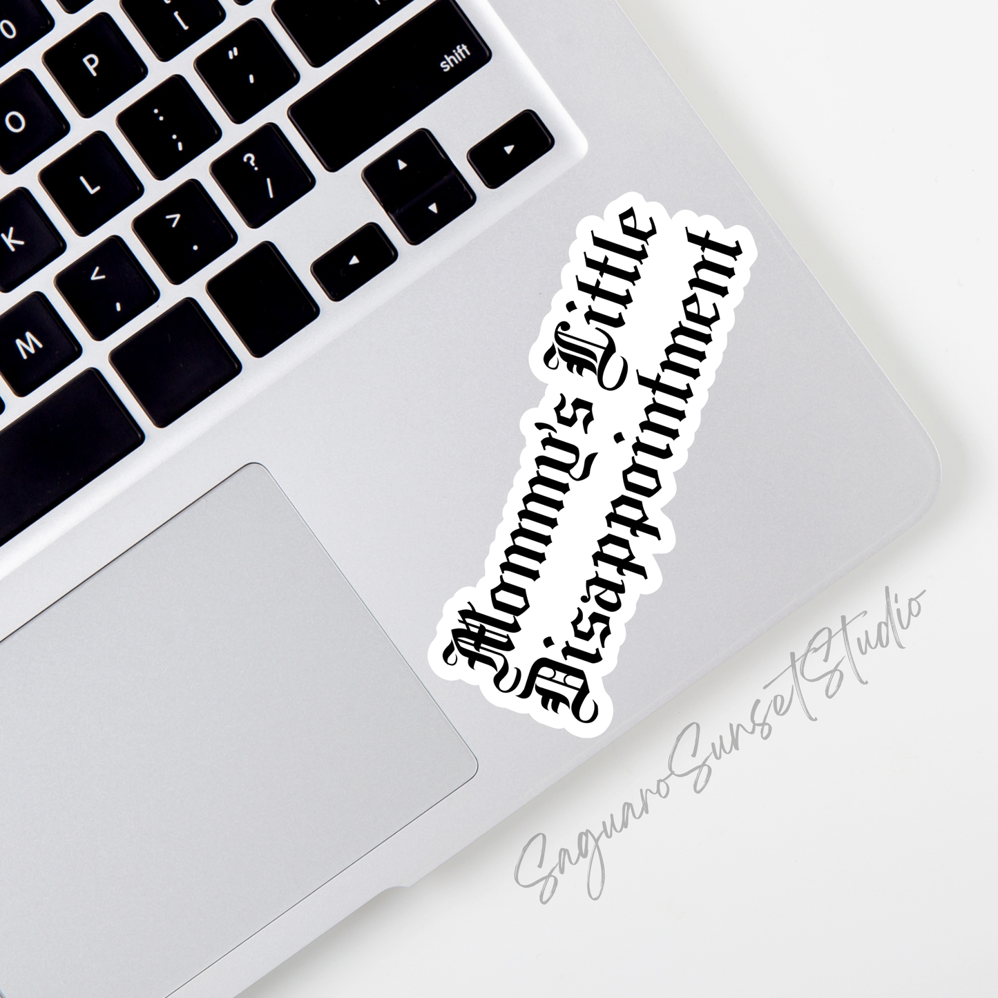 A white vinyl sticker with the phrase “Mommy’s Little Disappointment” written in bold black Gothic-style lettering.