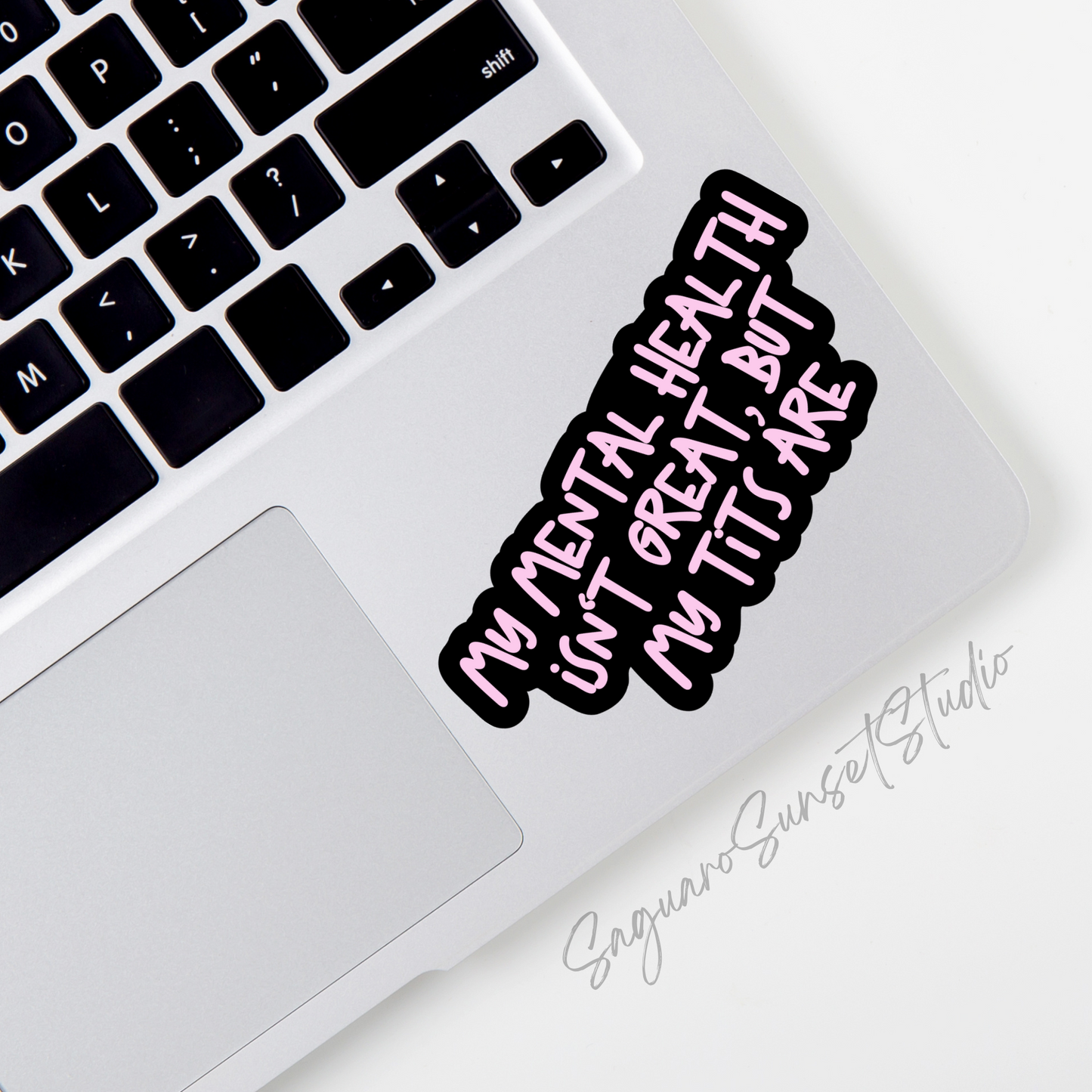 A sticker with bold pink lettering on a black background reading, "My Mental Health Isn't Great, But My Tits Are".