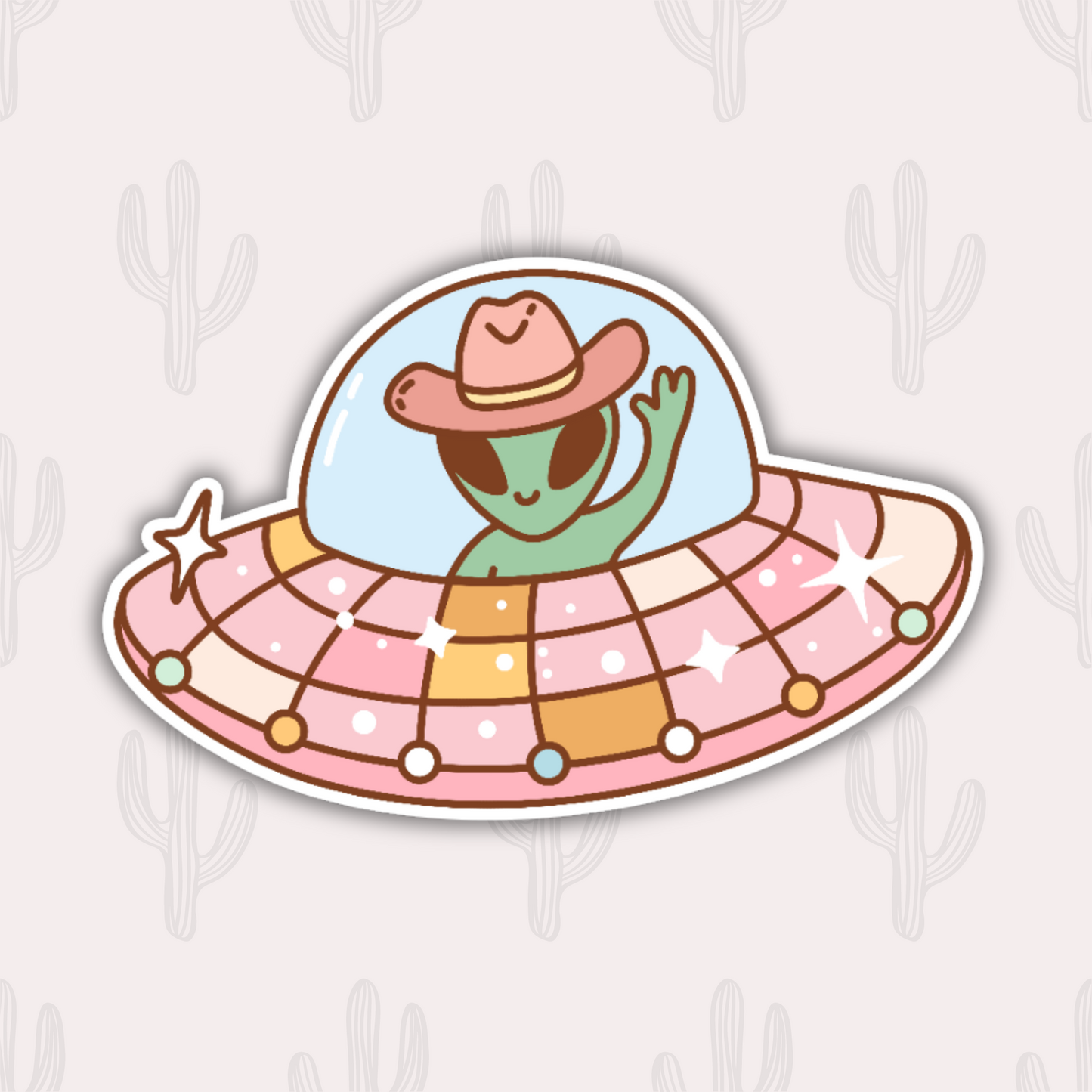 A sticker featuring a cute green alien wearing a cowboy hat, waving from inside a colorful and sparkly UFO. The UFO has a dome and is decorated with pastel colors and stars.
