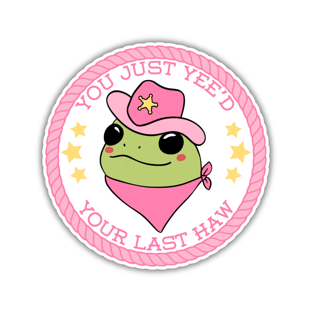 A round sticker featuring a green frog wearing a pink cowboy hat and bandana, surrounded by a pink rope border with the text "You Just Yee’d Your Last Haw" and yellow stars for added flair.