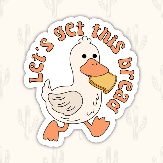 A sticker of a duck holding a piece of bread in it's mouth with the saying 'Let's get this bread'