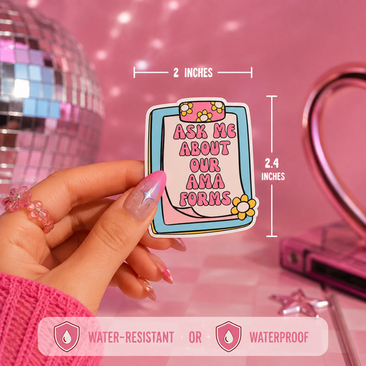A hand holds a die-cut sticker with a clipboard graphic and the text 'ASK ME ABOUT OUR AMA FORMS' in pink lettering. White dimension lines show the pin is 2 inches wide by 2.4 inches tall.