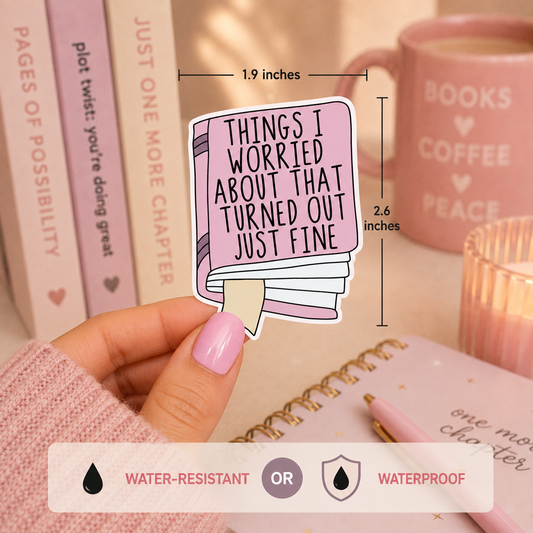 A hand holds a die-cut sticker shaped like a pink notebook page with the text 'THINGS I WORRIED ABOUT THAT TURNED OUT JUST FINE.' The image includes measurement callouts showing 1.9 inches wide by 2.6 inches tall