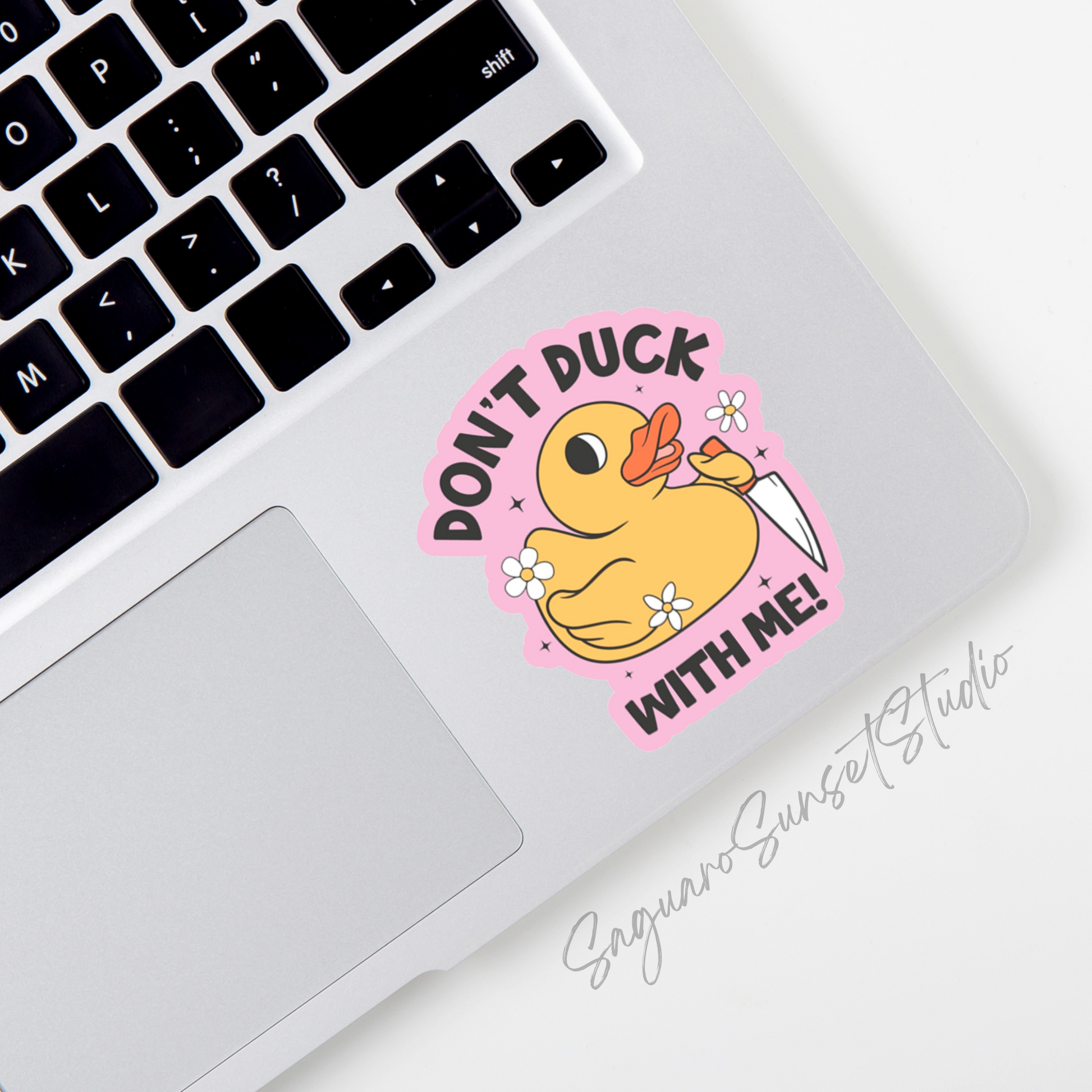 A pink sticker with a yellow rubber duck holding a knife with the phrase 'Don't duck with me!"