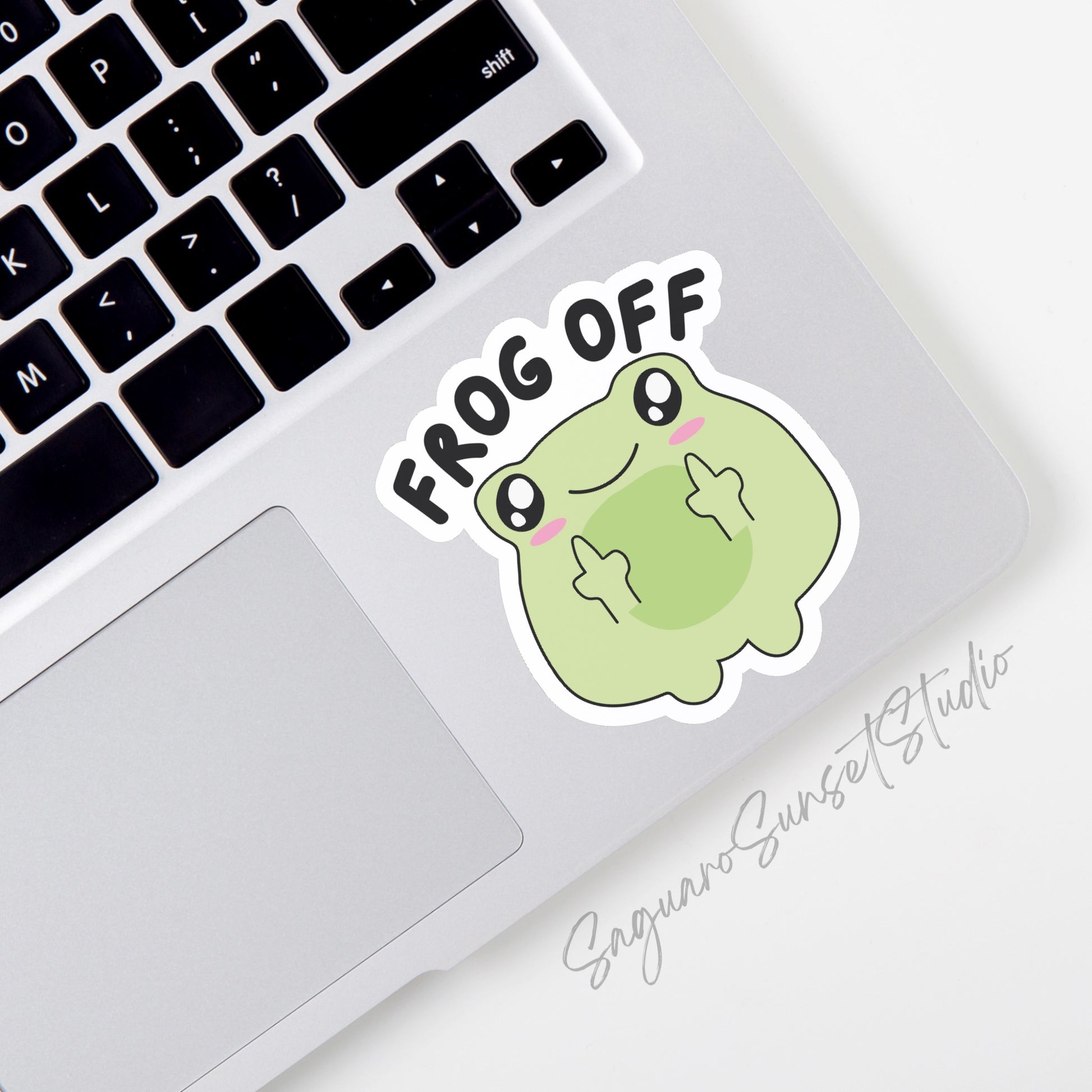 A vinyl sticker featuring a cute green frog with a mischievous expression, showing two middle fingers, with the text "Frog Off" above the frog