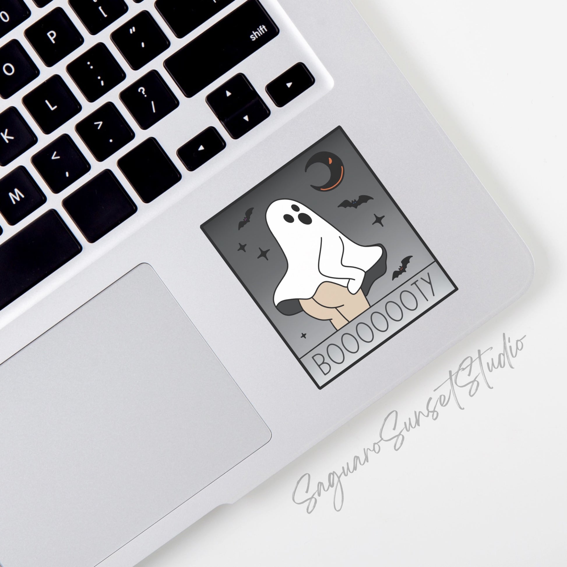 A vinyl sticker featuring a ghost lifting its sheet to reveal a booty, with the word "Booooooty" below, set against a grey background with bats, stars, and a crescent moon.