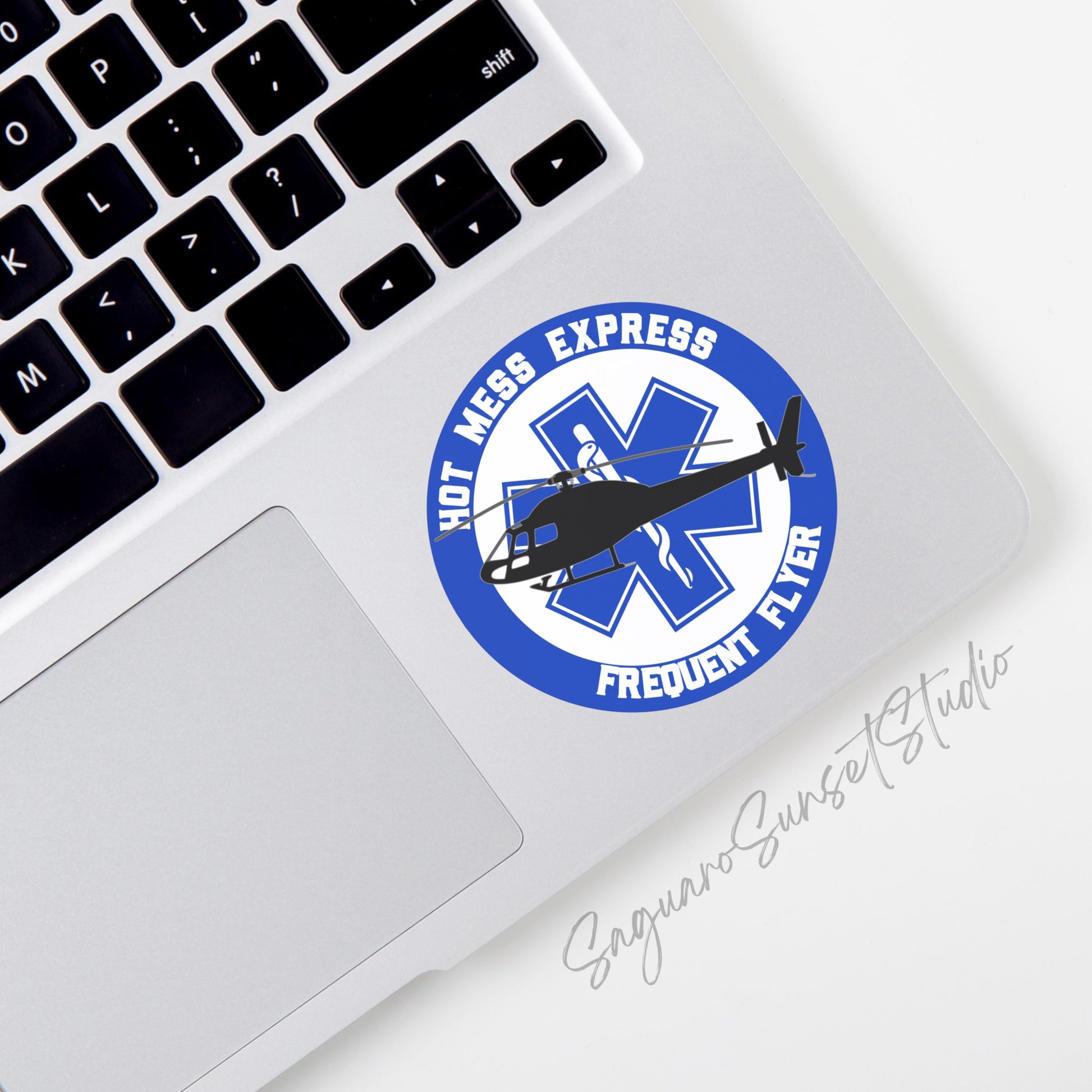 A vinyl sticker featuring a helicopter silhouette over a medical star of life symbol with the phrase "Hot Mess Express Frequent Flyer" in bold text around the circle