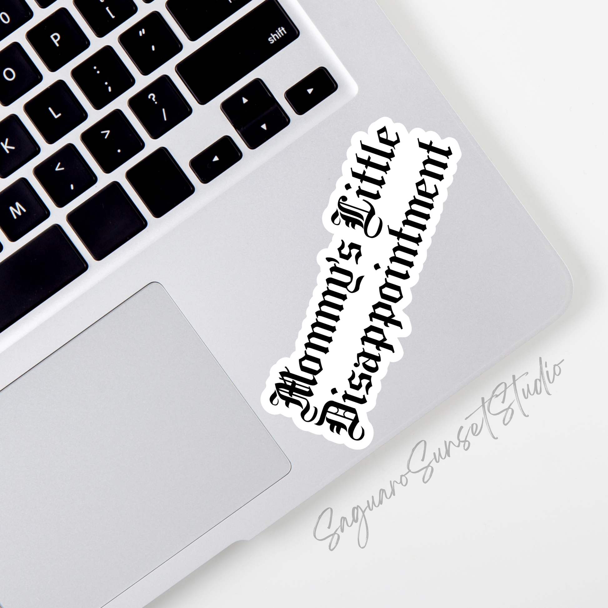 A white vinyl sticker with the phrase “Mommy’s Little Disappointment” written in bold black Gothic-style lettering.