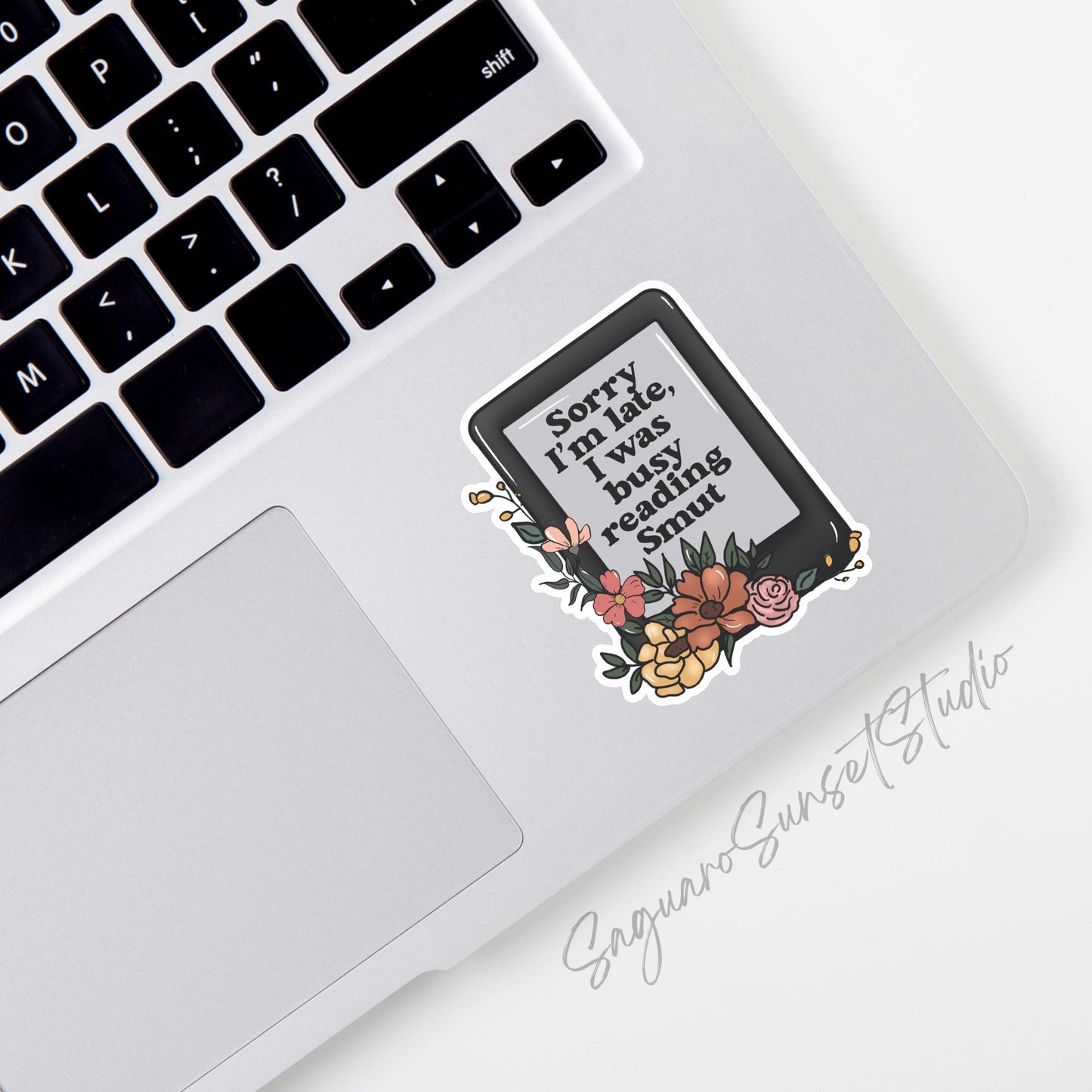 Sticker featuring an e-reader with flowers and the phrase "Sorry I’m Late, I Was Busy Reading Smut," designed for book lovers and readers.