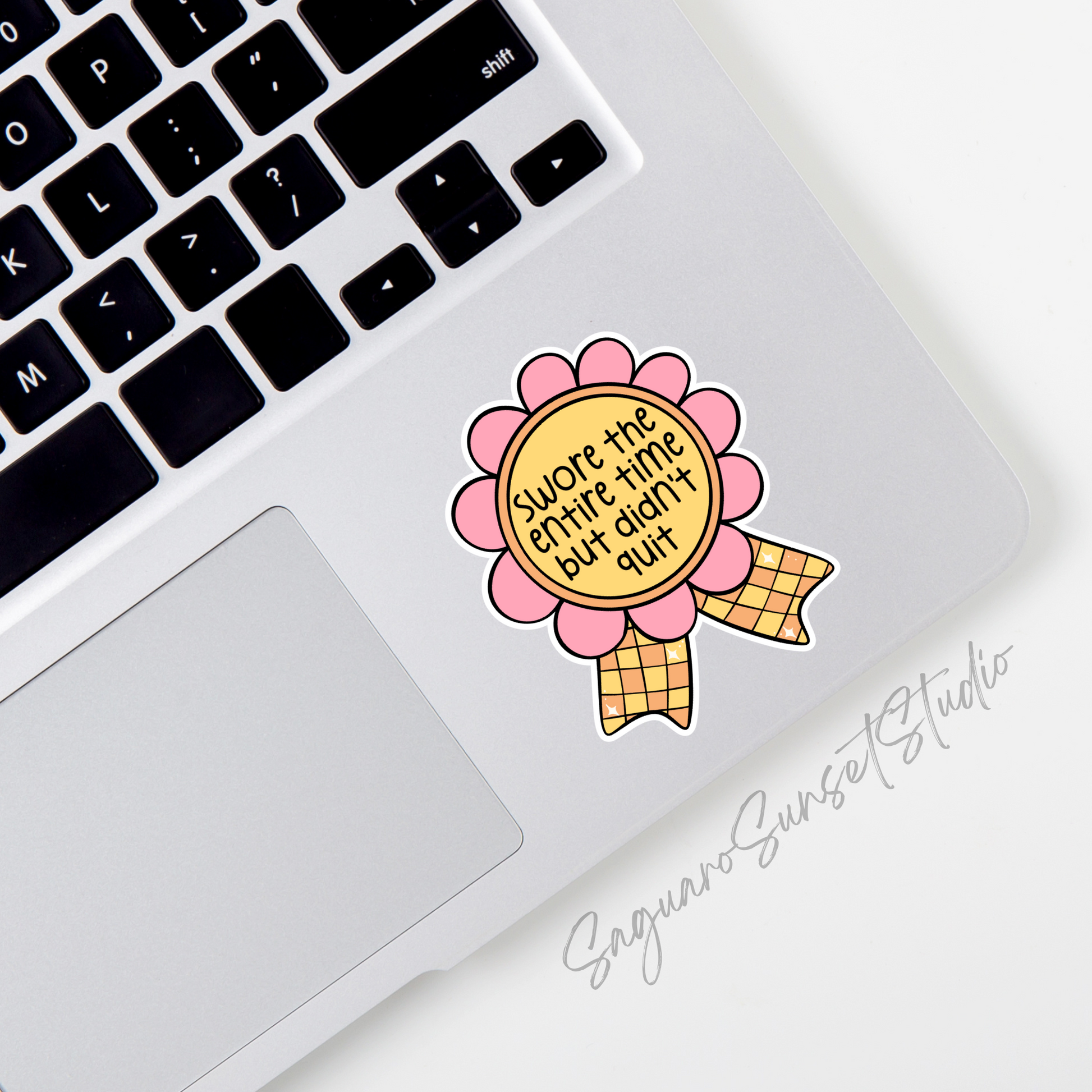 A sticker featuring a pink and yellow award ribbon with the text "Swore the Entire Time But Didn’t Quit" in bold, playful font, perfect for celebrating perseverance with humor.