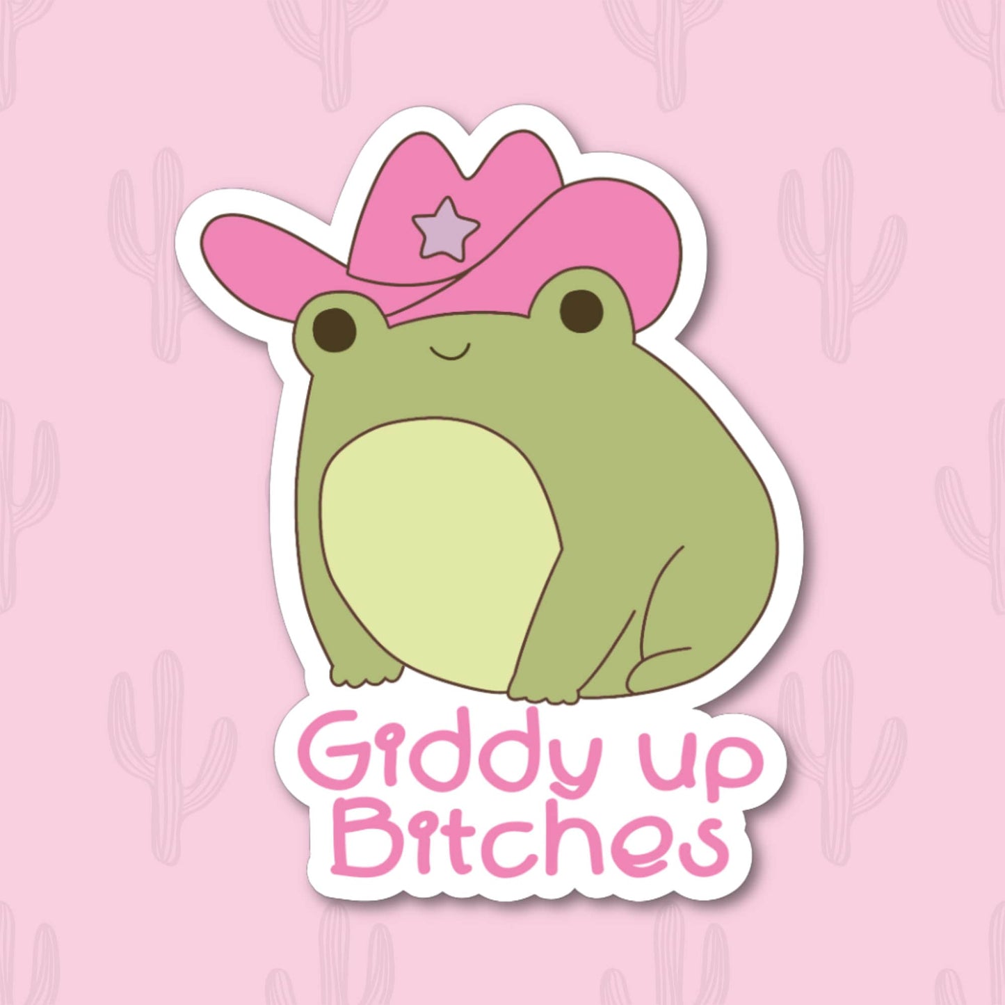 A vinyl sticker featuring a cute frog wearing a pink cowboy hat with the phrase "Giddy Up Bitches" in playful pink text