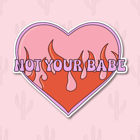 Sticker featuring a retro heart with flames and the phrase "Not Your Babe," designed to be cute, sassy, and evoke a Y2K aesthetic.