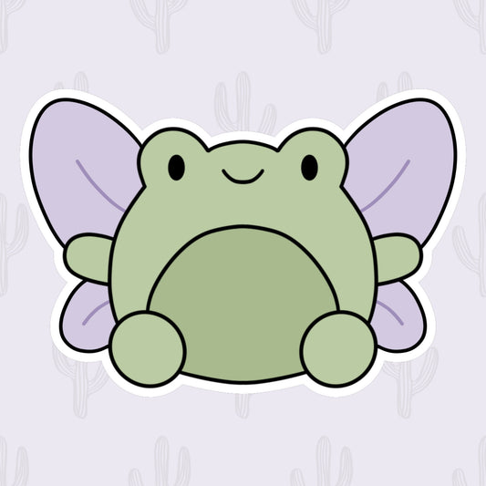 A vinyl sticker featuring a cute green frog with lilac colored fairy wings