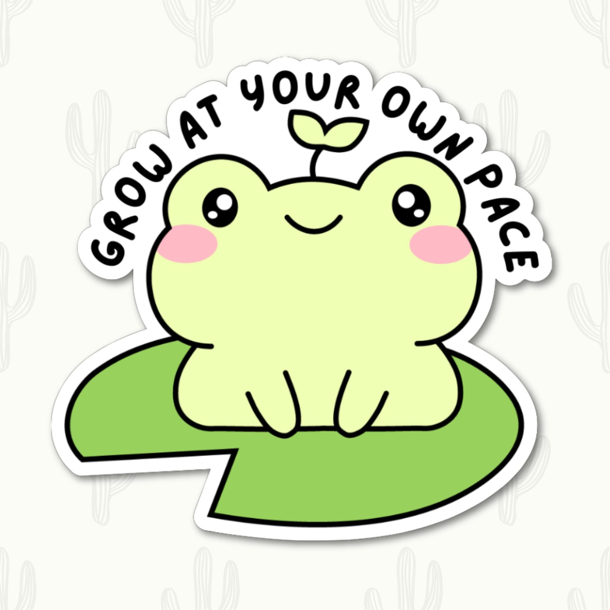 A vinyl sticker featuring a cute frog with a sprout on its head sitting on a lily pad, with the phrase "Grow at Your Own Pace" written above