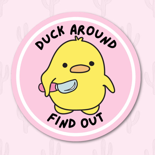 A round vinyl sticker featuring a cute yellow duck holding a small knife, with the phrase "Duck Around Find Out" written in bold black text above and below the duck. 