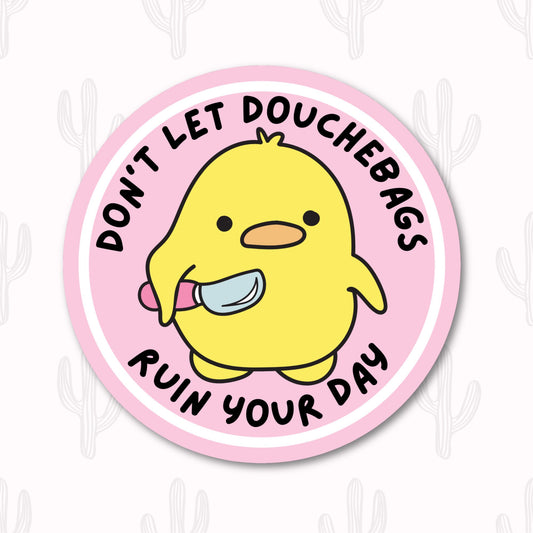 A round sticker featuring an adorable yellow duck holding a small knife, with the phrase "Don't Let Douchebags Ruin Your Day" written in black text around the duck. 